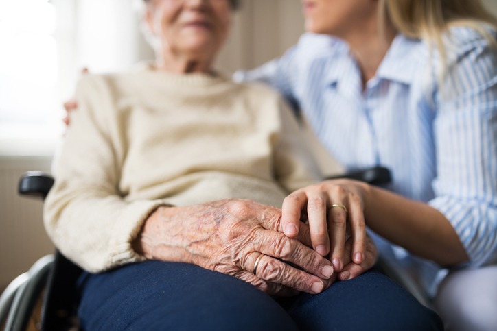 persona anziana con familiari a fianco